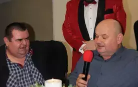 Tenor Krzysztof Filasiński i dw&oacute;ch mężczyzn. jeden z mężczyzn trzyma mikrofon i śpiewa kolędę