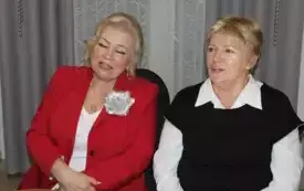 Kwie kobiety - Danuta Drzymulska przewodnicząca Gminnej Rady KGW i Marianna Radzięda - przewodnicząca Wojew&oacute;dzkiej Rady KGW siedzą obok siebie za wigilijnym stołem.