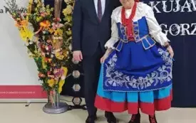 Mężczyzna w garniturze stoi z kobietą w stroju ludowym