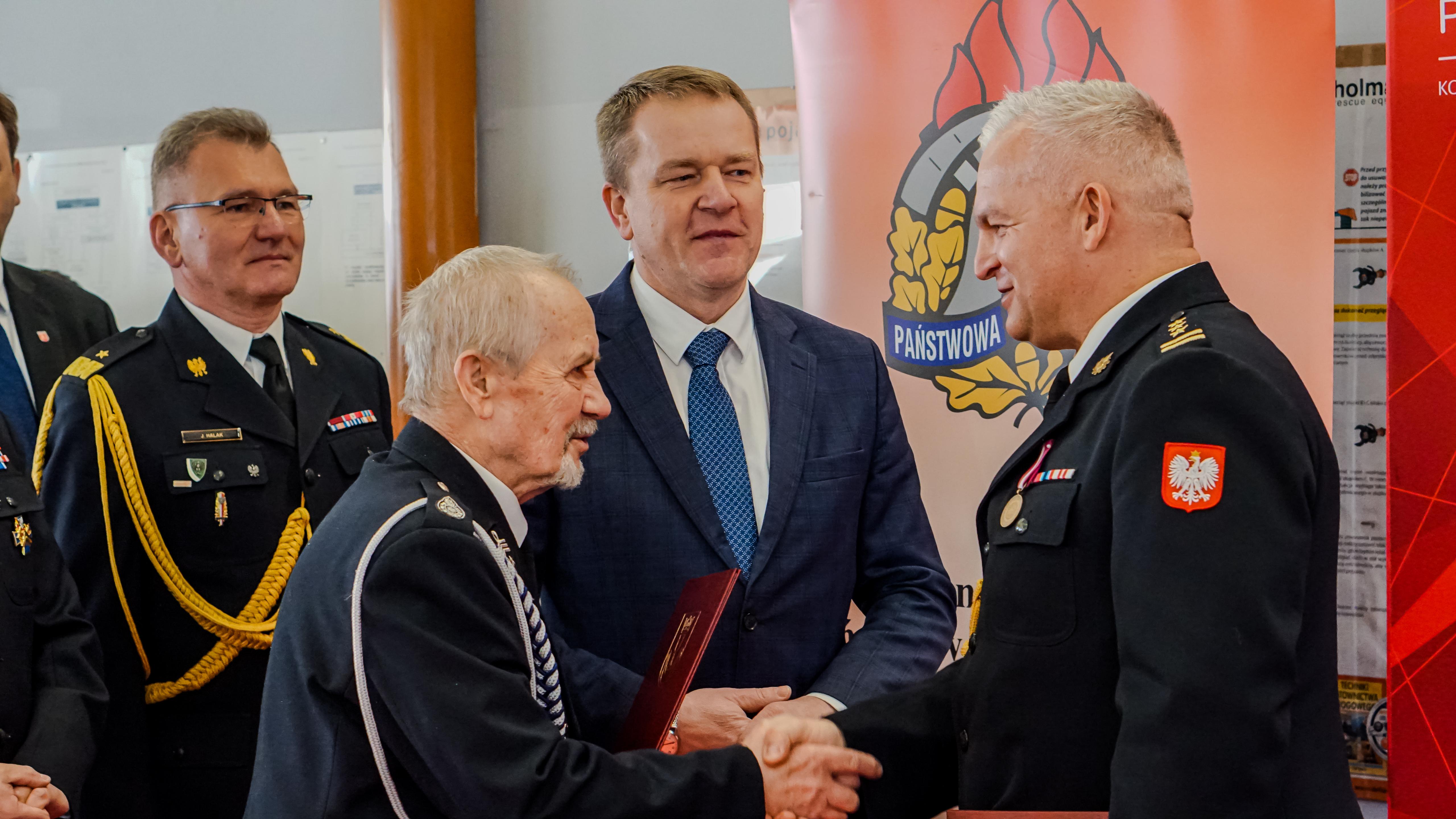 Dw&oacute;ch Pan&oacute;w w&nbsp;mundurach podaje sobię dłoń.