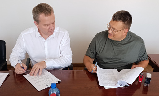 Dwóch mężczyzn podpisuje dokumenty